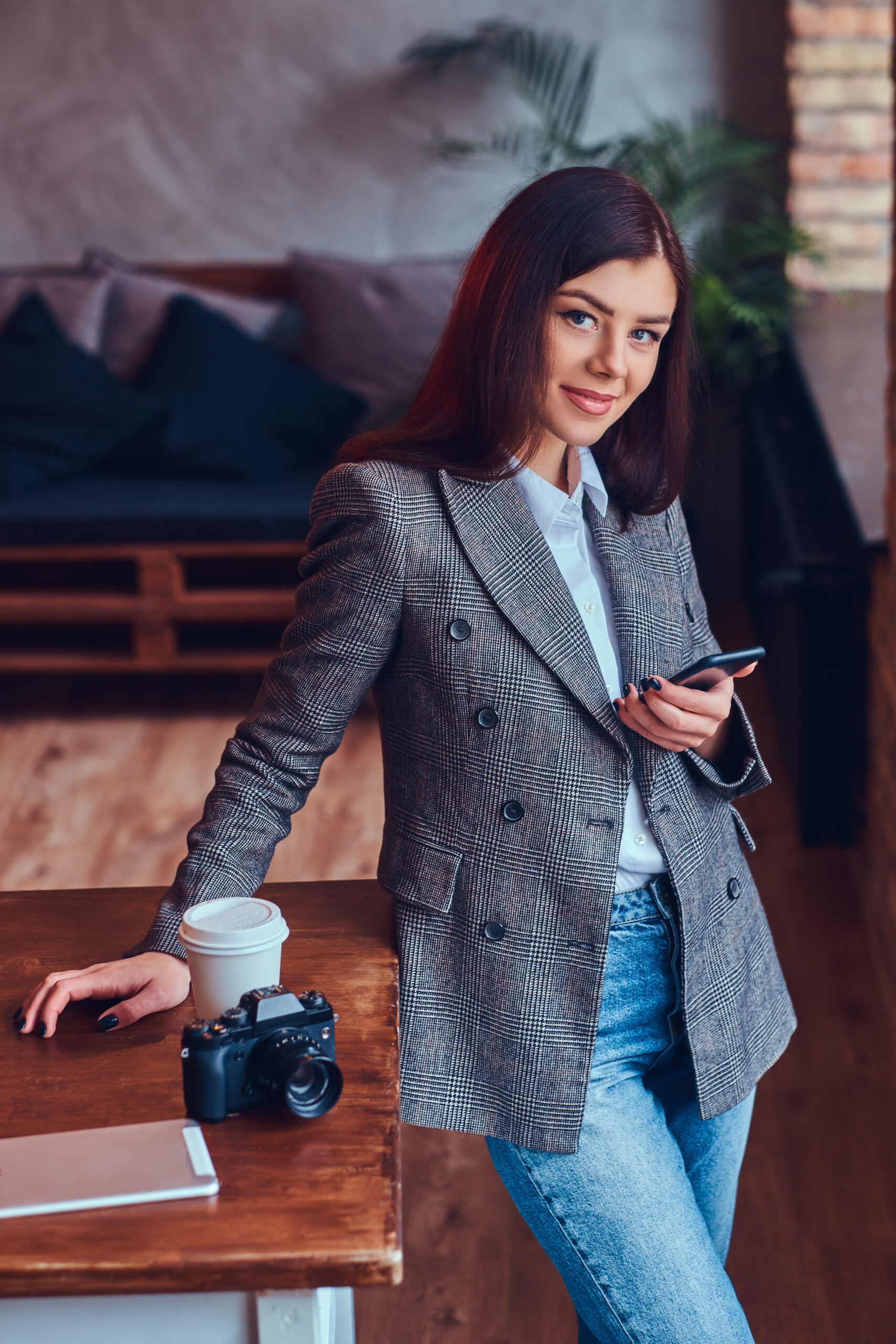 portrait of a young female photographer works with a phone leani